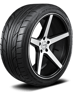 Close-up of a car tire mounted on alloy wheel rim with a black background.