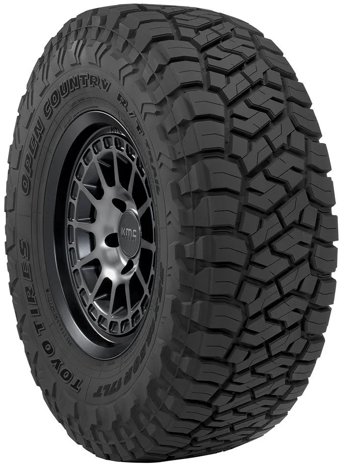 A close-up of an off-road tire with a rugged tread pattern, mounted on a black alloy wheel, designed for durability and traction.