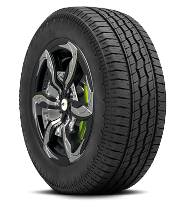 A car tire with black alloy wheel and green accents on the brake caliper.