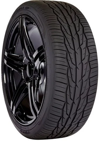 Close-up of a black car tire with detailed tread pattern and black alloy wheel rim