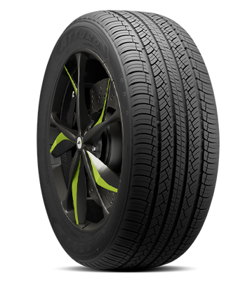 A car tire mounted on a rim with black and green accents.