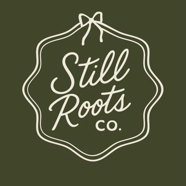 Logo with a decorative border and a bow at the top, reading 'Still Roots co.' on a dark green background.