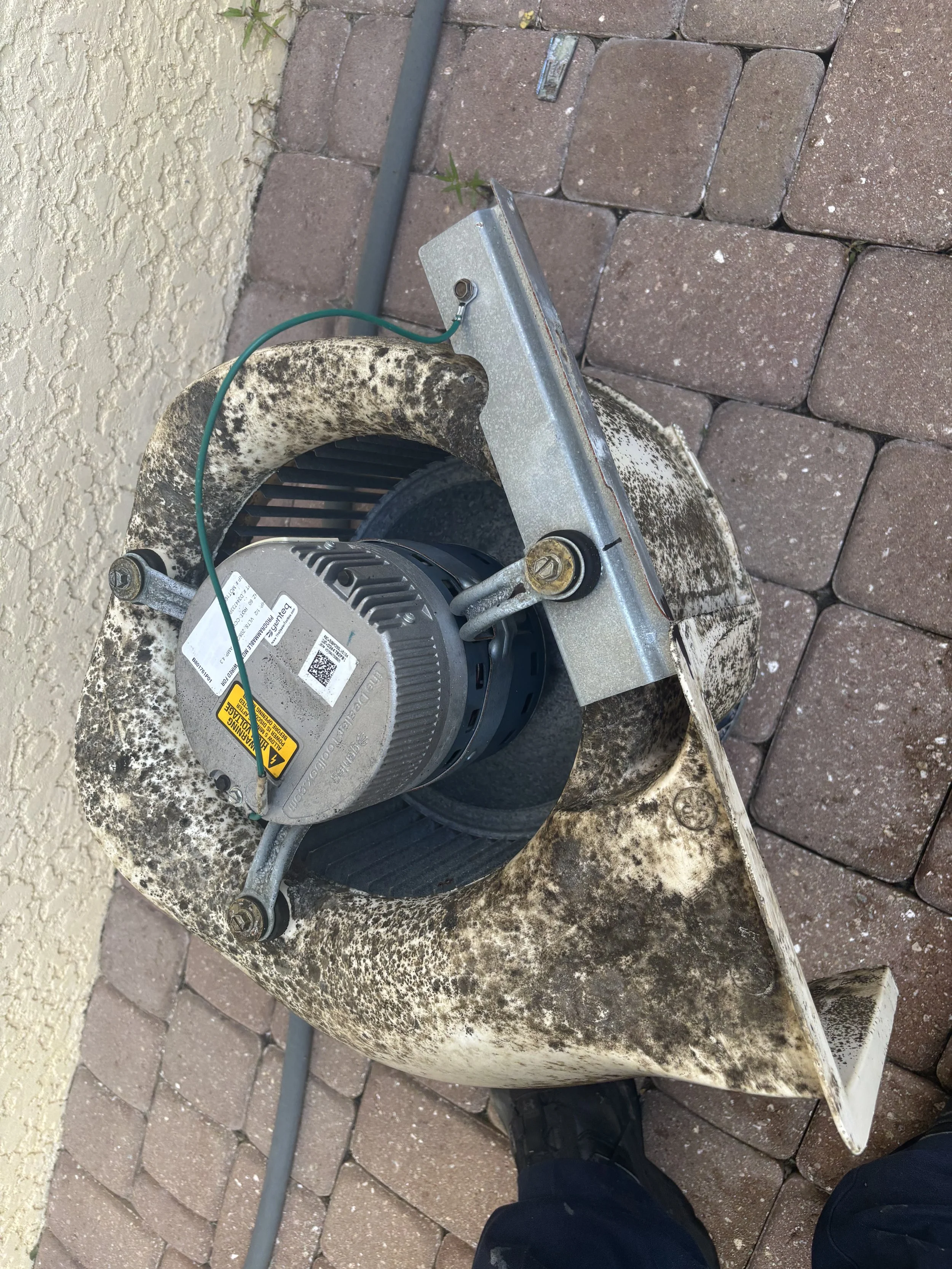 Indoor blower wheel with grime and rust on housing, removed from the unit for cleaning .