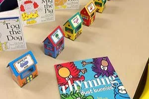 Colorful miniature toy houses and children's books on a table.
