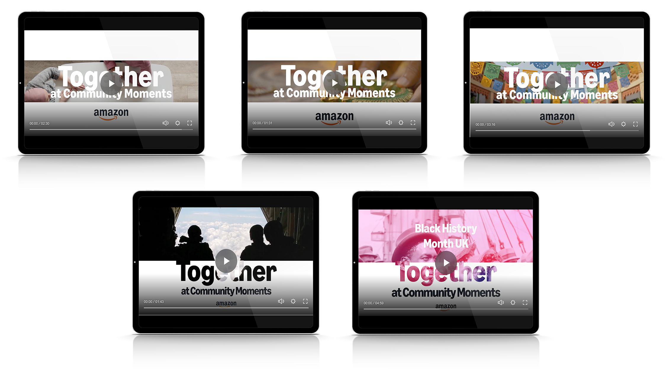 Five tablets displaying videos with community themes, some showing people, cakes, decorations, and text such as 'Together at Community Moments' and 'Black History Month UK,' with the Amazon logo on all screens.