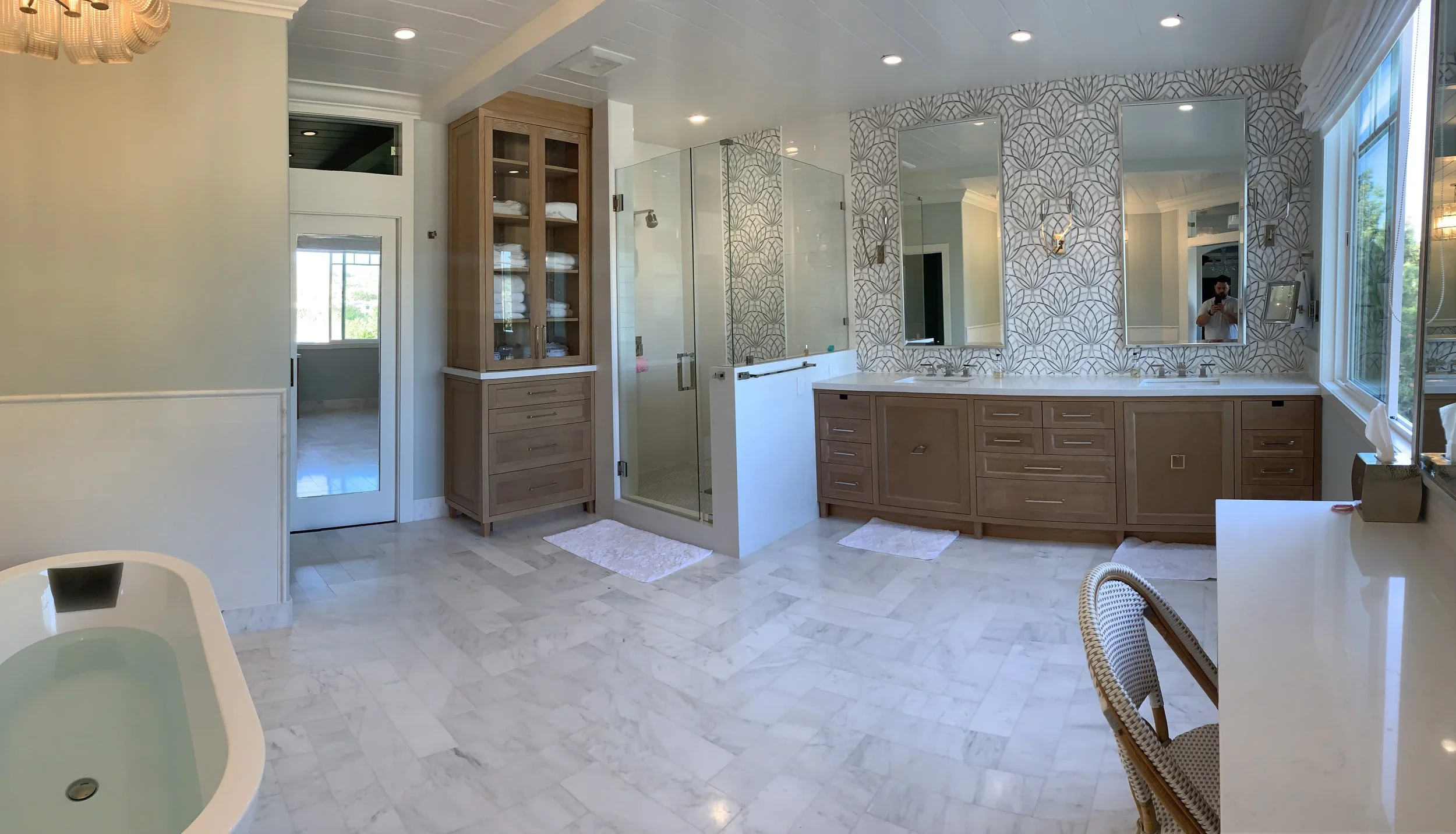 Marble bathroom and shower with white oak linen cabinet and large double vanity