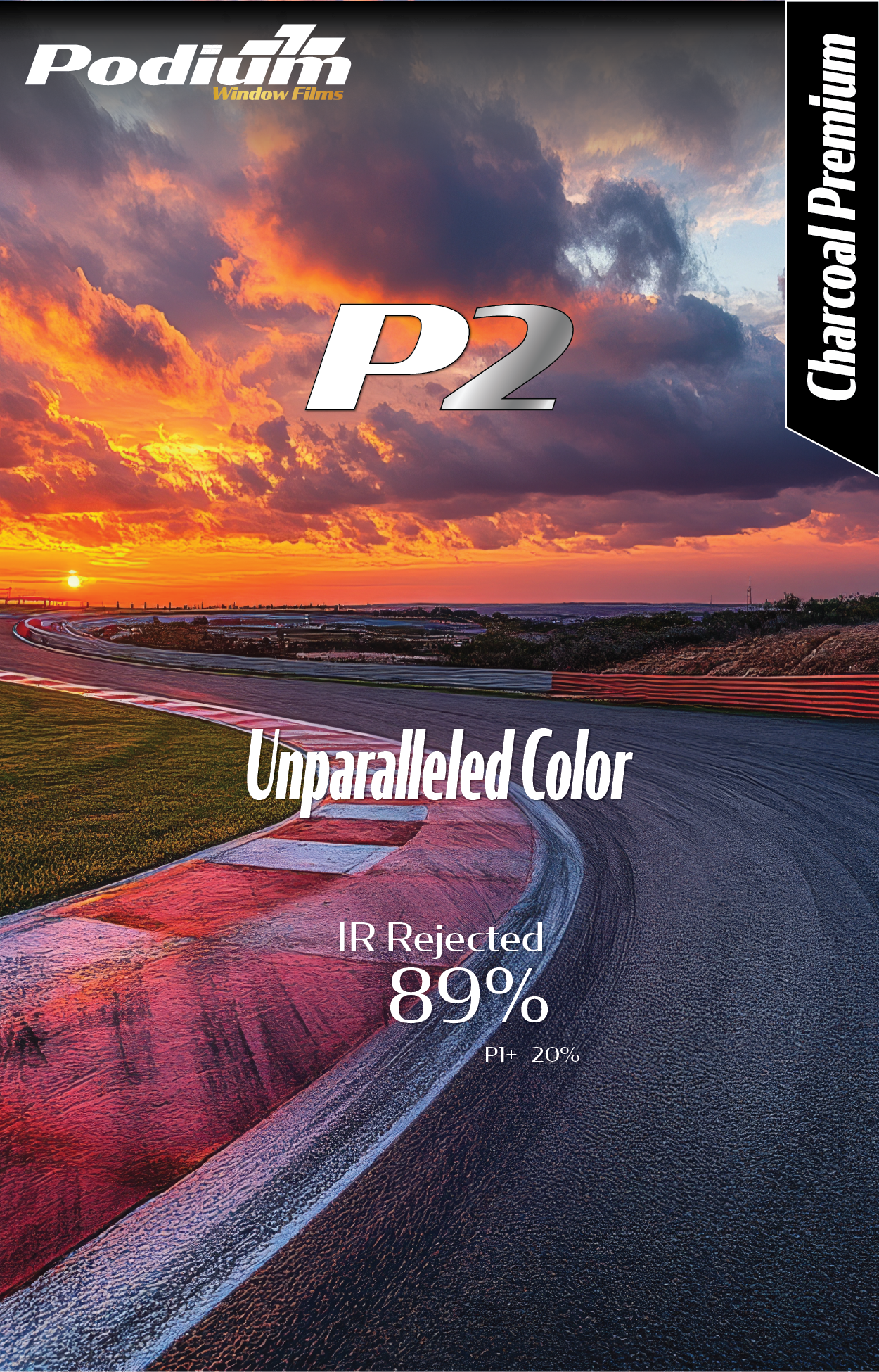 A racing track at sunset with vibrant clouds and a colorful sky, featuring curved asphalt and painted curbs.