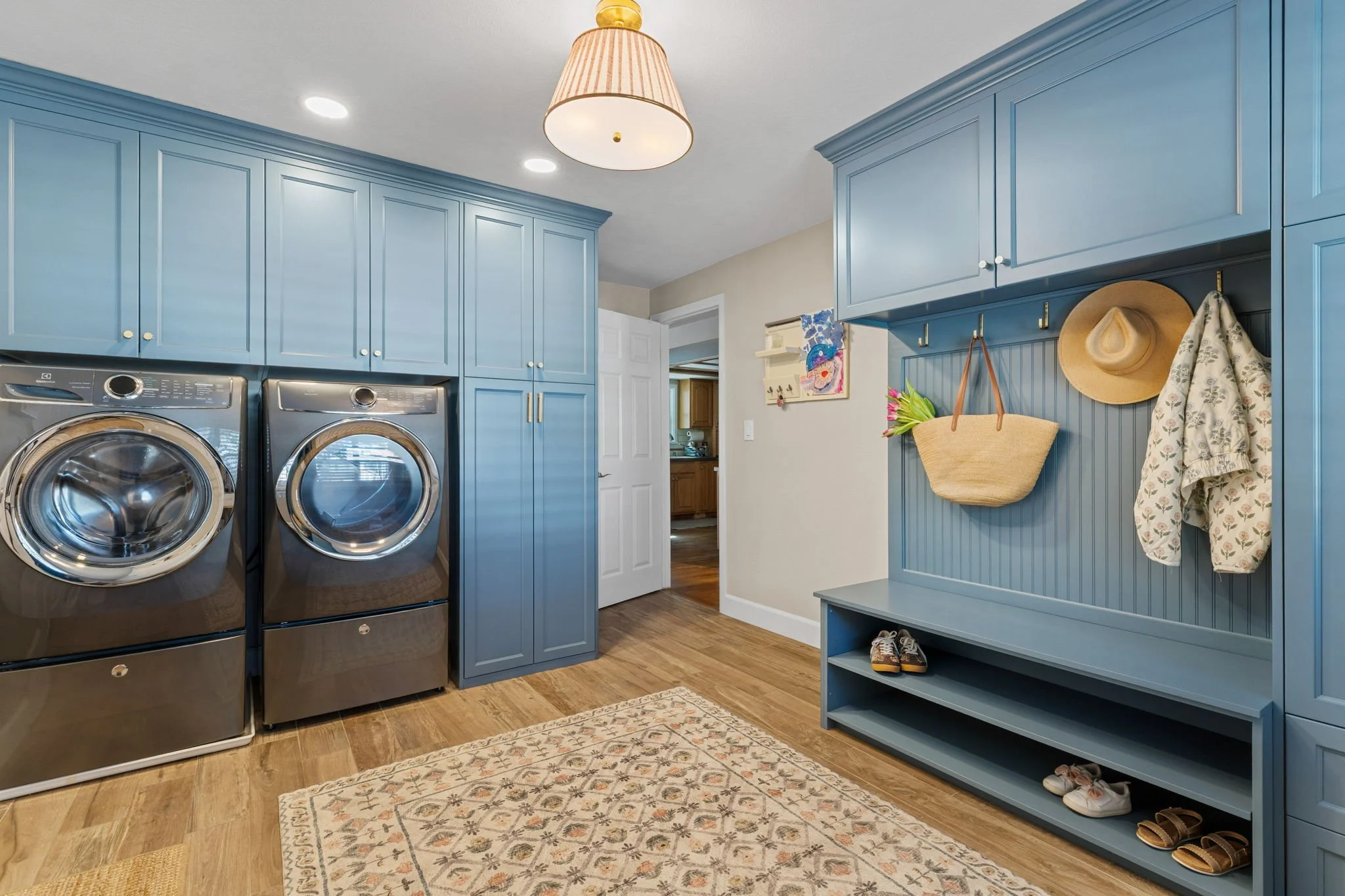 A Navy laundry room combo set consisting of washer/dryer storage unit and integrated bench unit.