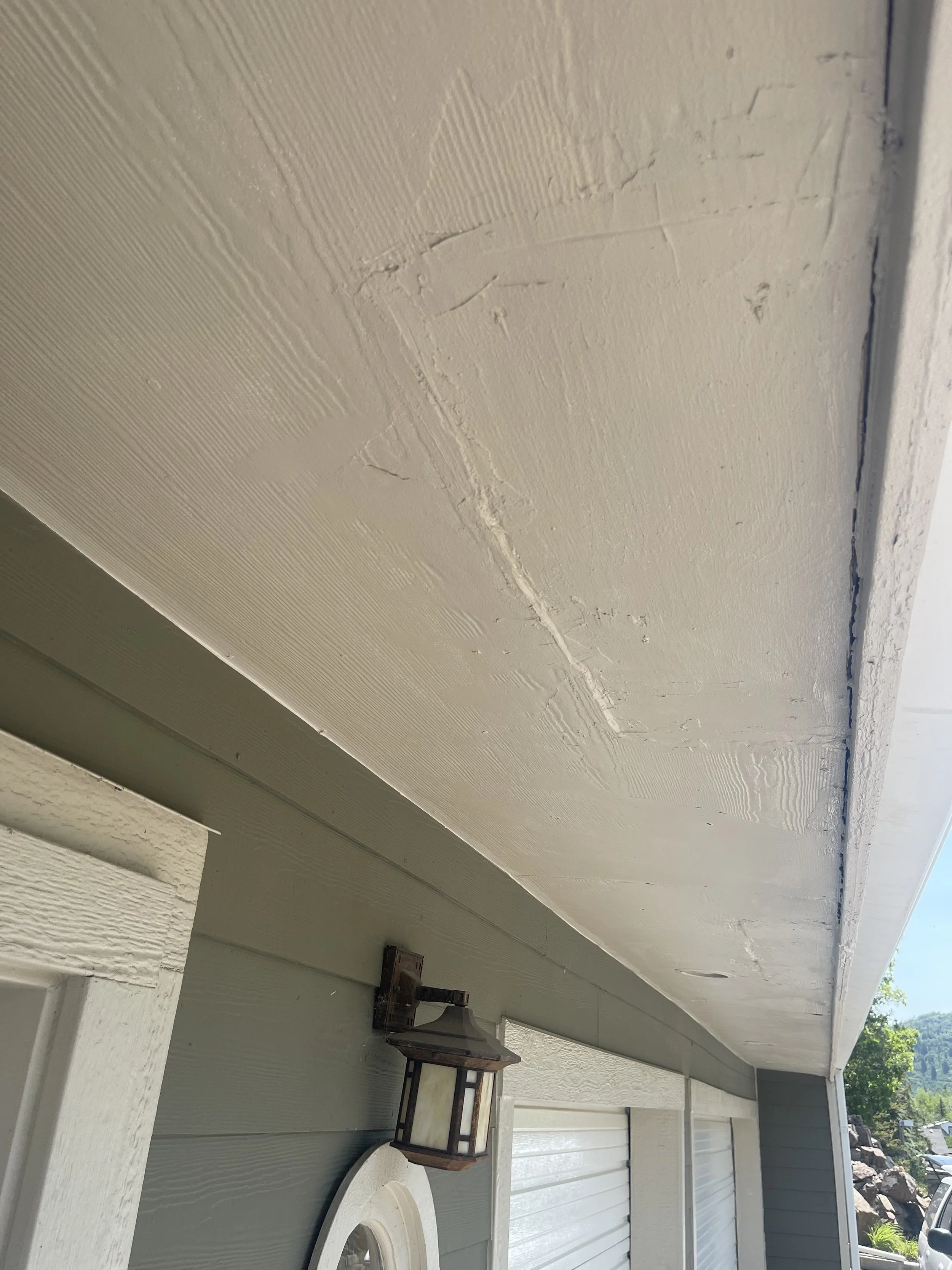 Close-up image of an exterior house soffit, showing visible cracks and signs of damage.