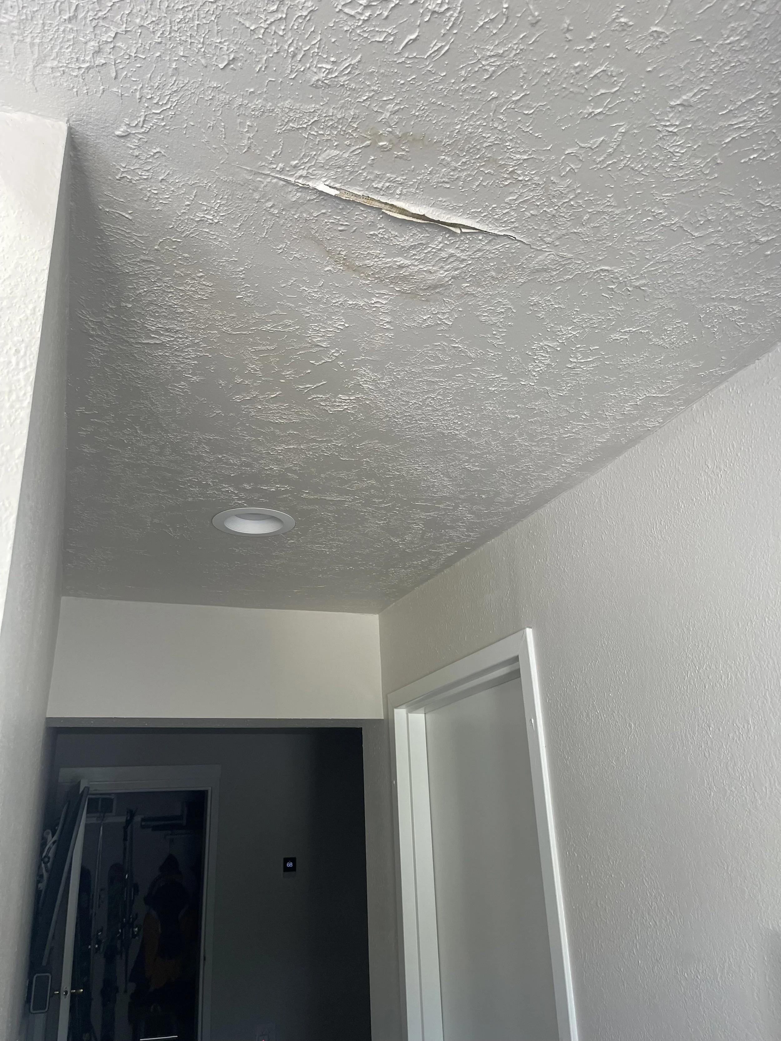Ceiling with a large crack in textured finish.