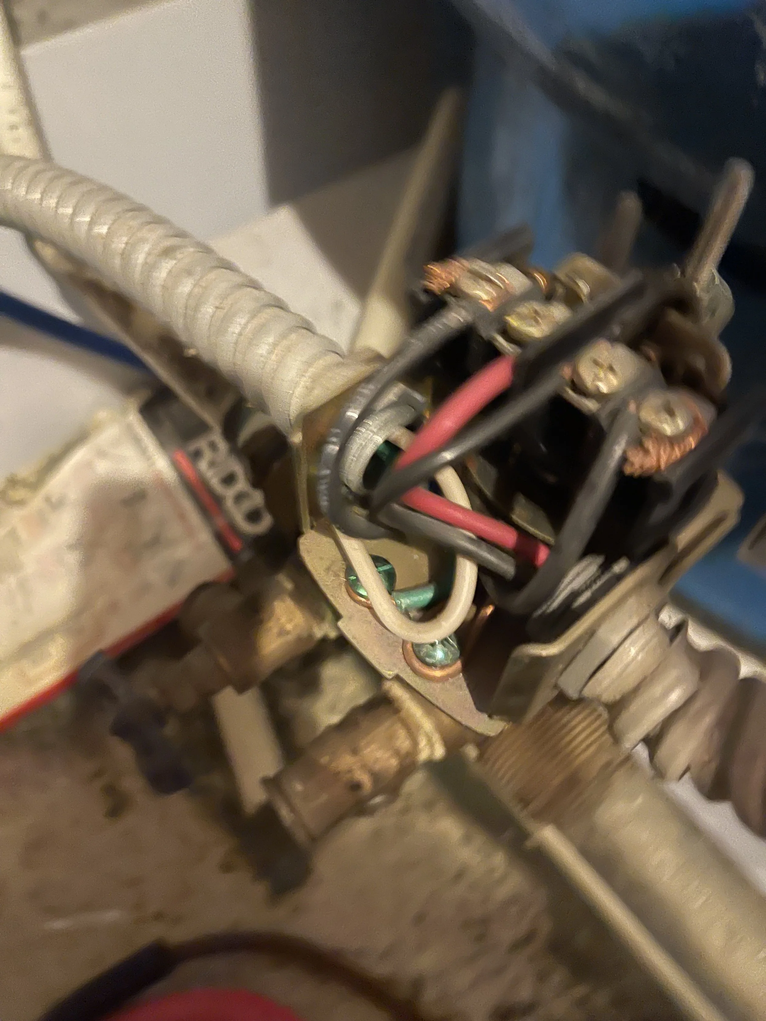 Close-up of an electrical component with wires and connectors, showing a mechanical assembly inside a machine.