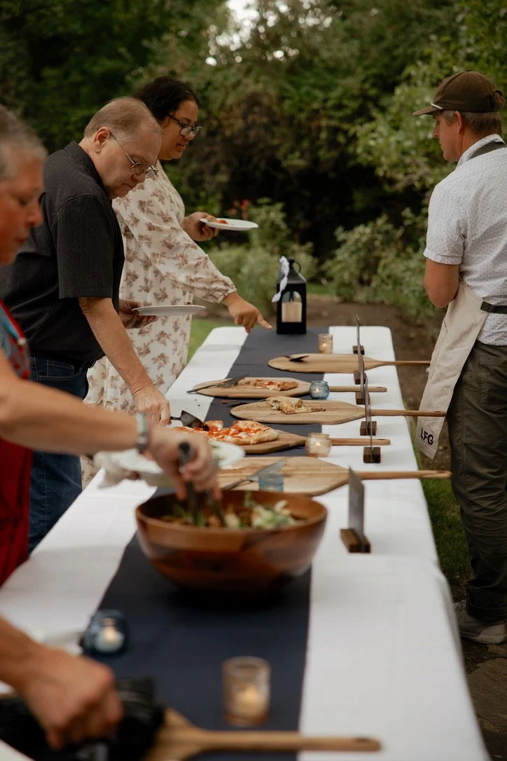 Guests gathered around the live-fire pizza table