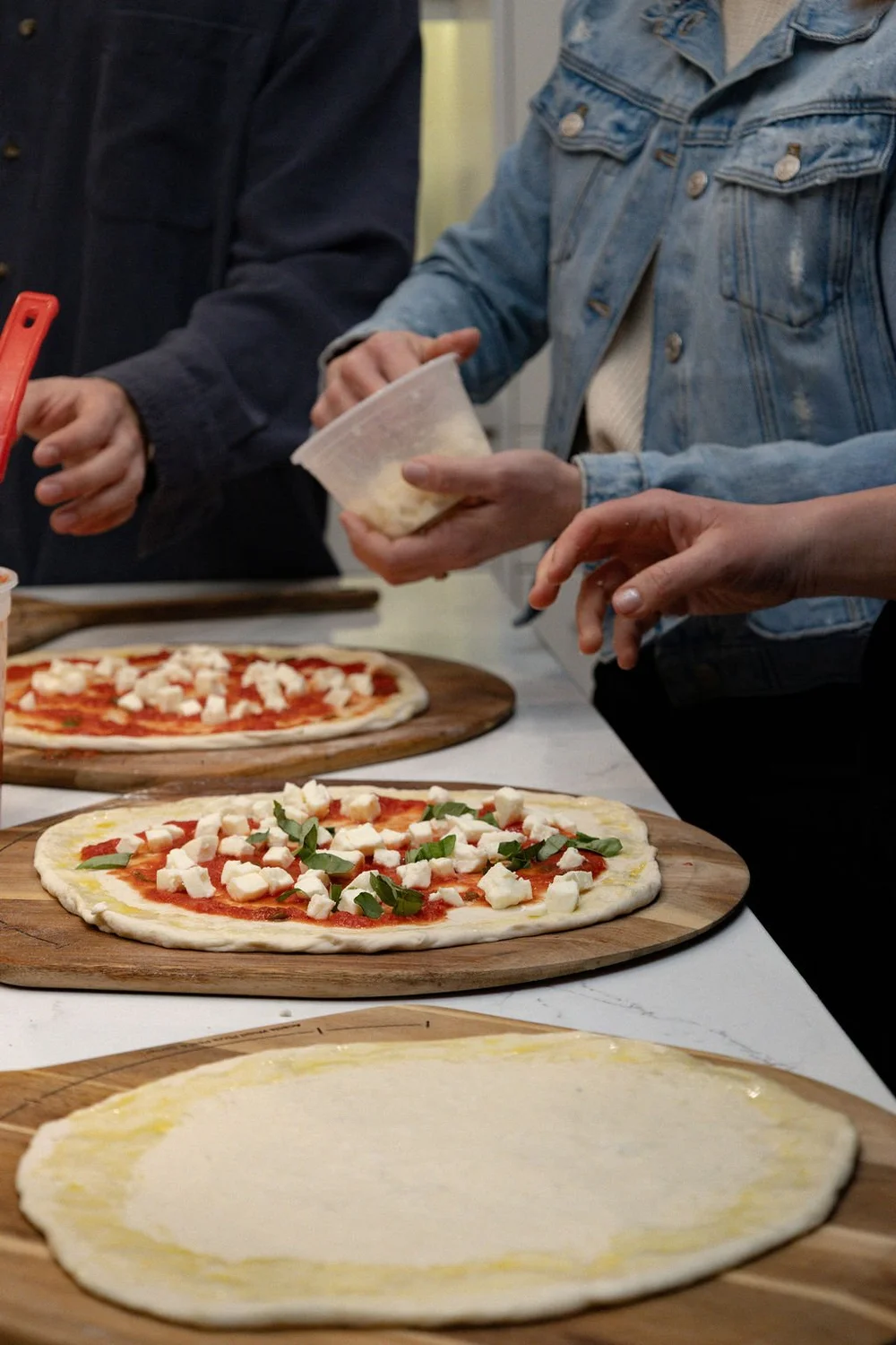 Freshly topped pizzas on the class table