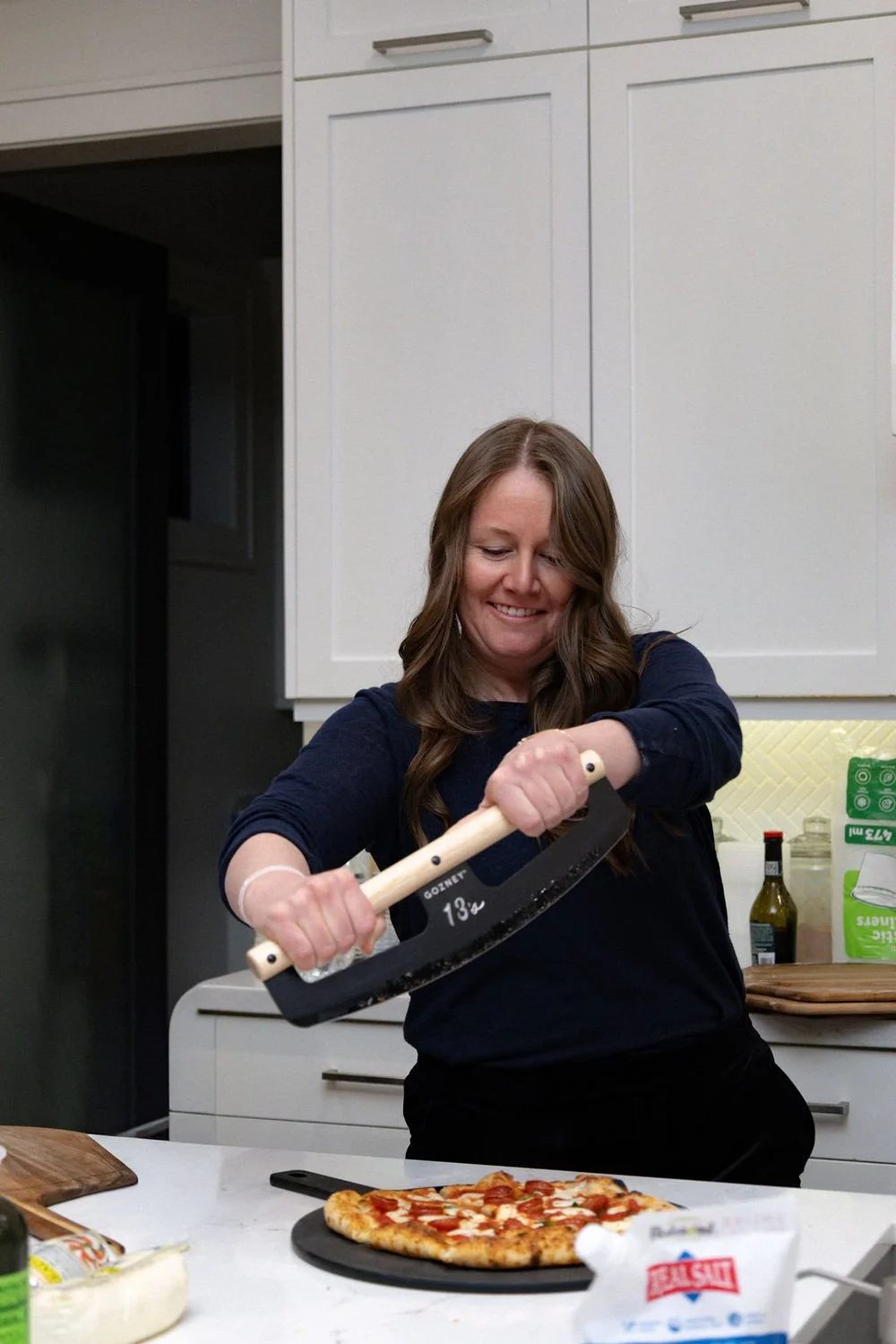 Guest preparing pizza during a pizza class