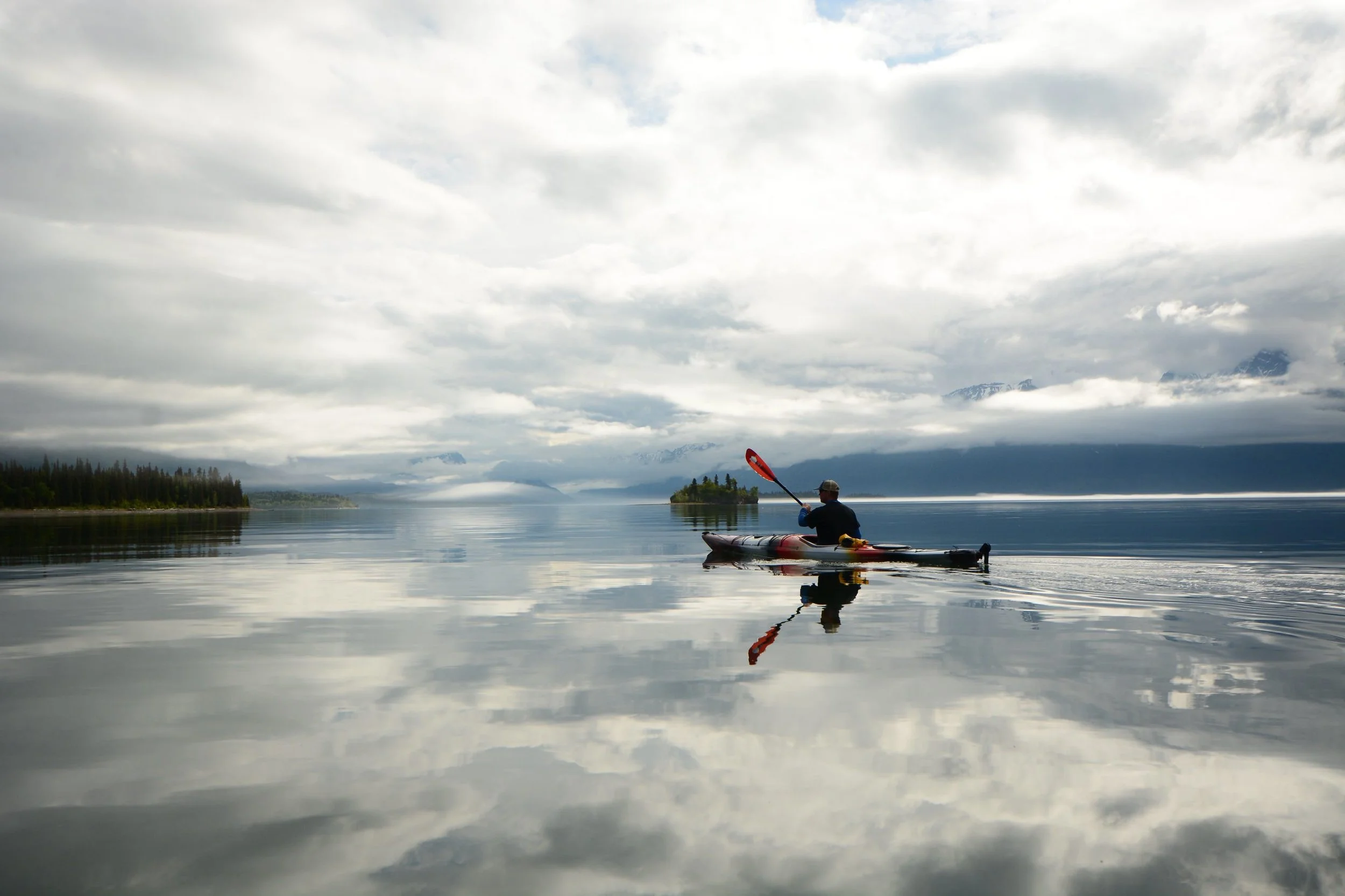 Kayaker paddling calm waters of Lake Clark