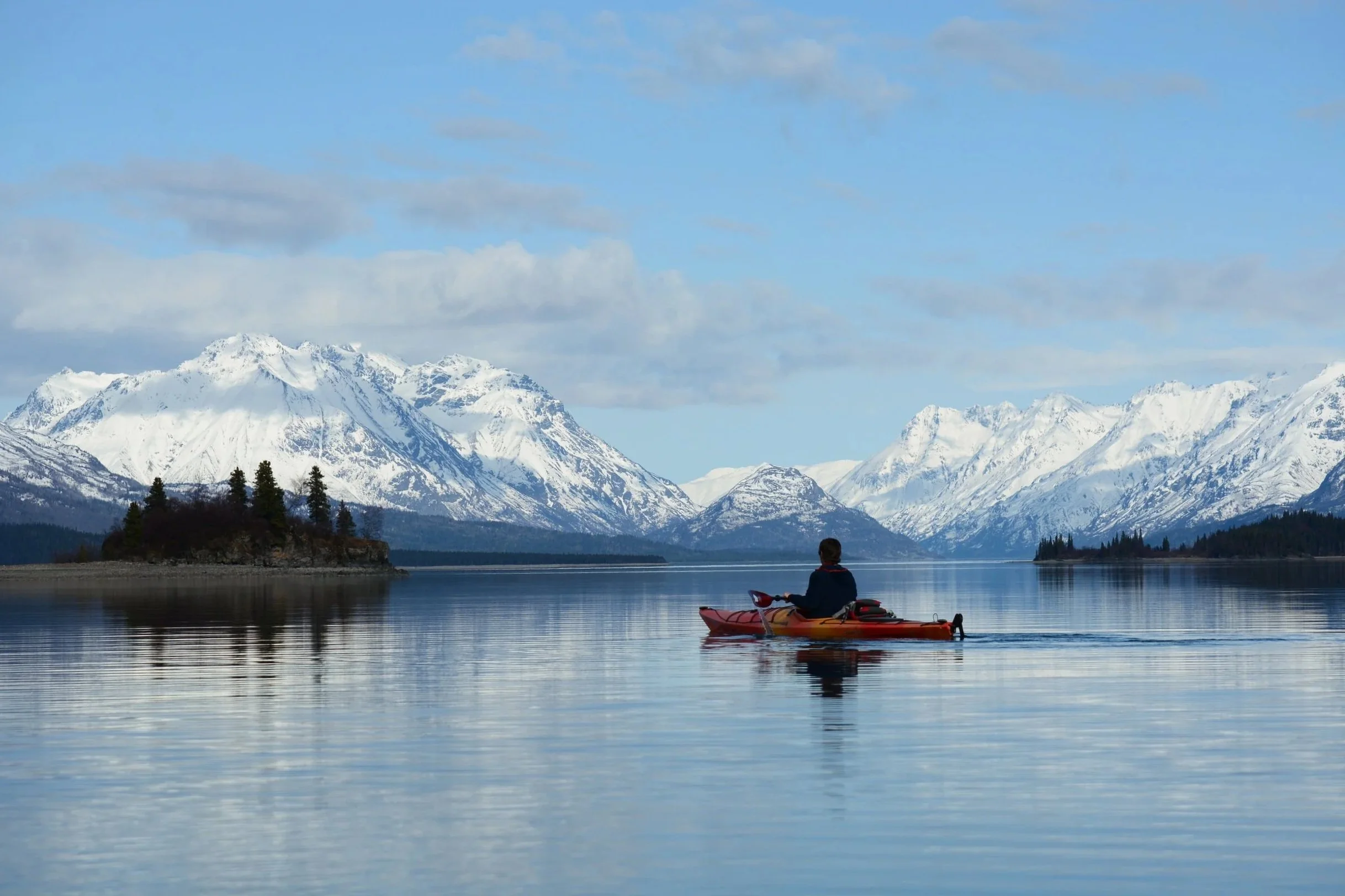 Kayakers on Lake Clark with snowcapped mountains