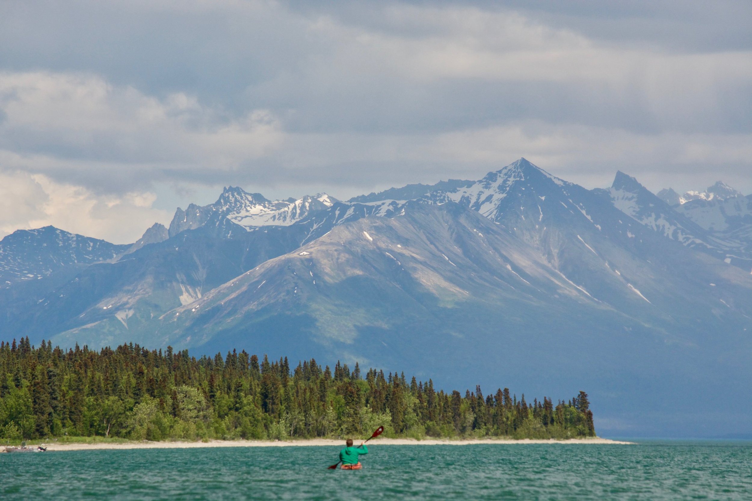 Kayaker and views of Chigmit Mountains on Lake Clark National Park