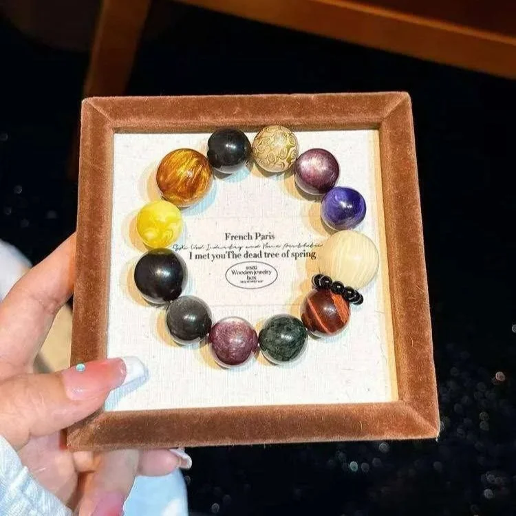 Colorful bracelet with various large beads displayed in a brown velvet box