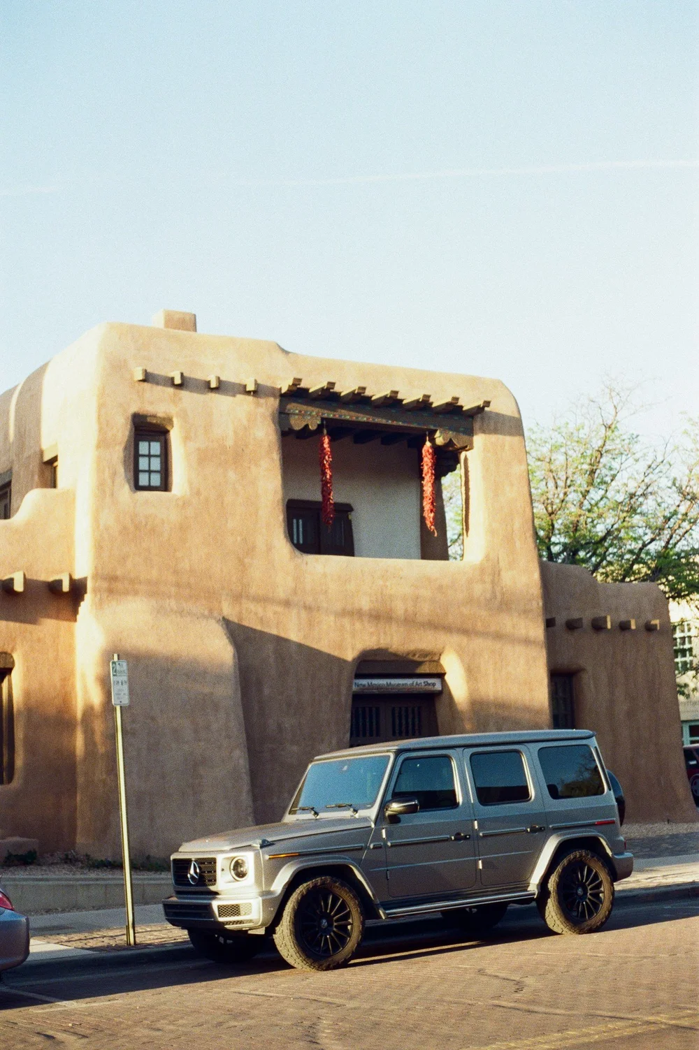 An adobe building and a silver SUV, Santa Fe, on Kodak 400