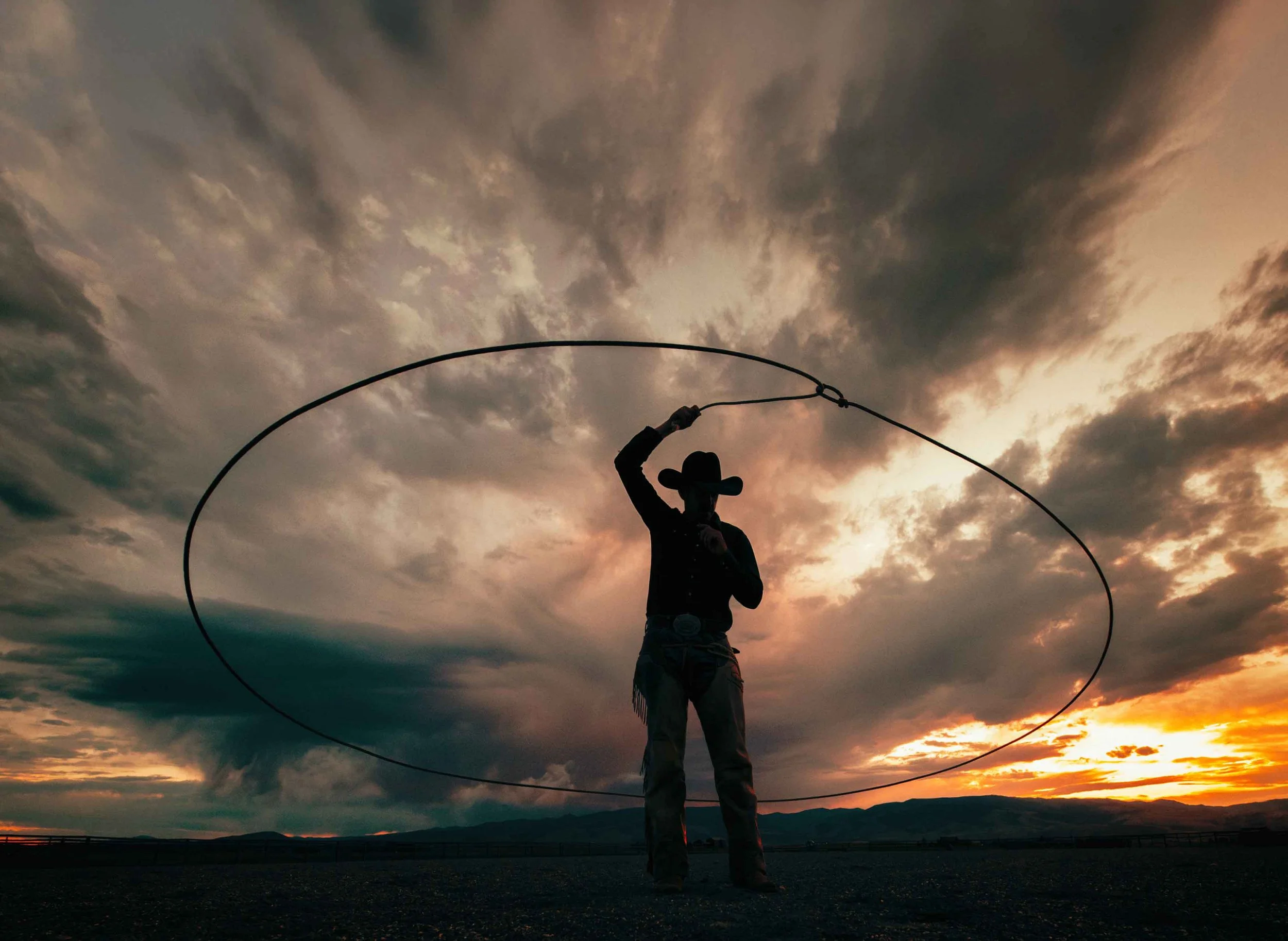 A roper at sunset, the loop mid-air, from the Leather Vintage Label campaign for Tru Western