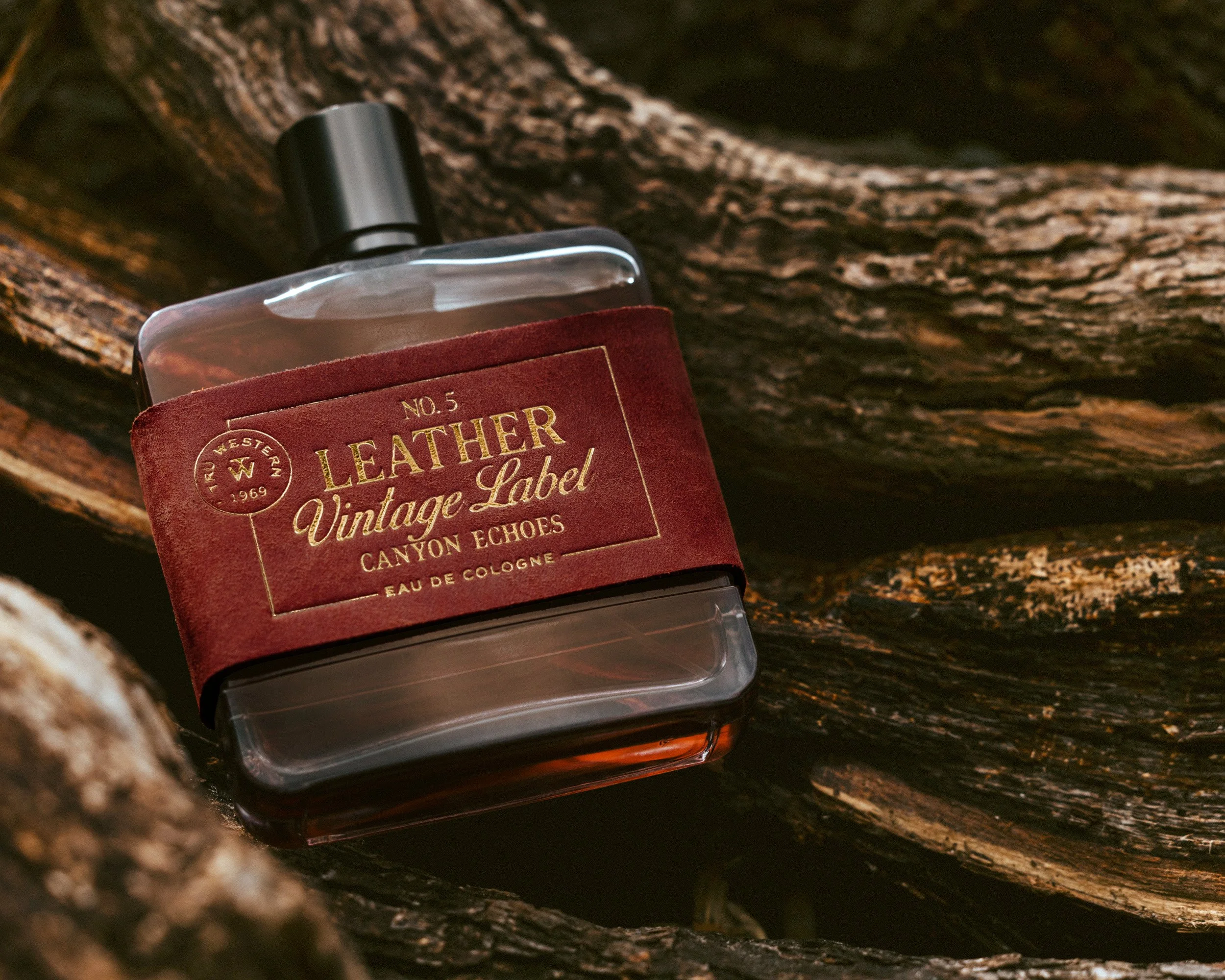 No. 5 Leather Vintage Label: Canyon Echoes lying across weathered wood, its red suede label stamped in gold foil.