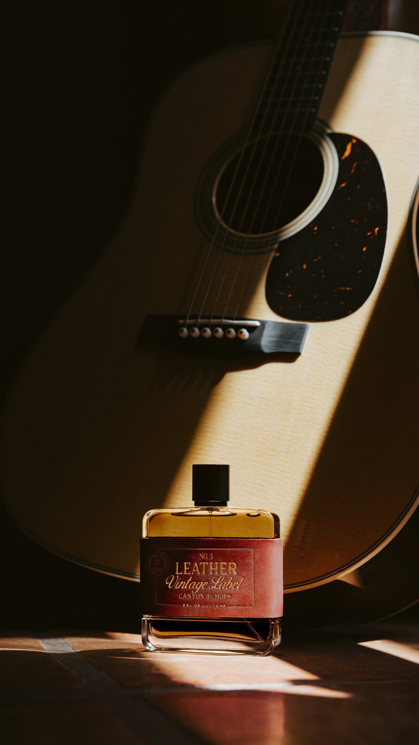 No. 5 Leather Vintage Label: Canyon Echoes at the foot of an acoustic guitar, a hard slice of sunlight across the body.