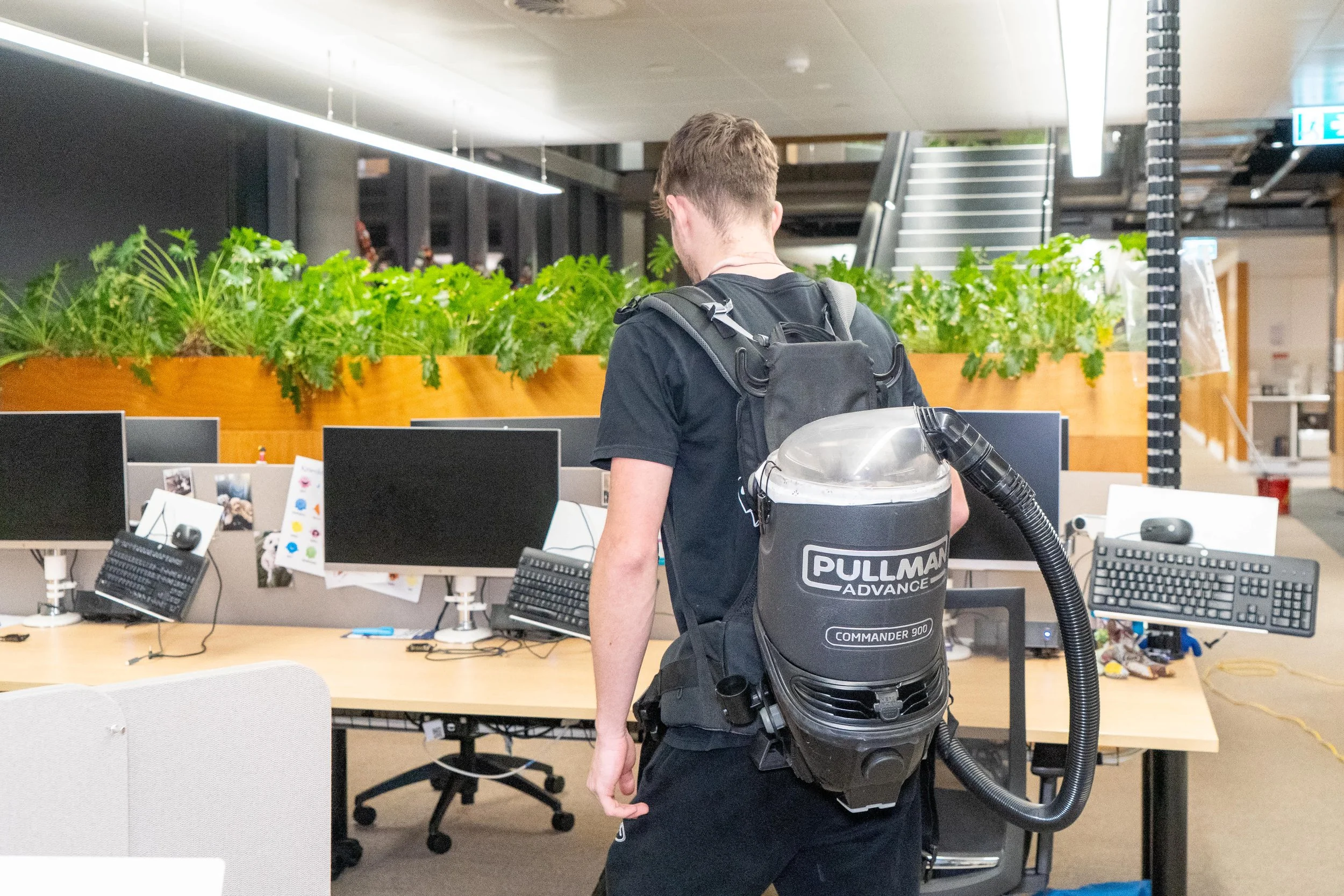 lady vacuuming carpet in office building