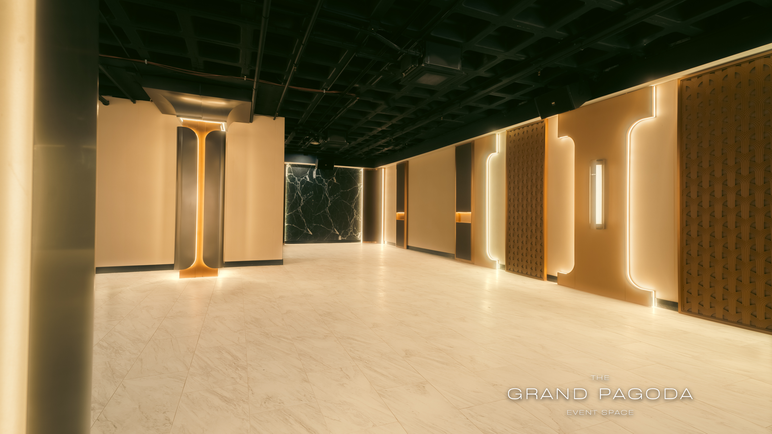 Interior of a modern event space called The Grand Pagoda with sleek lighting, marble wall accents, and contemporary decor.