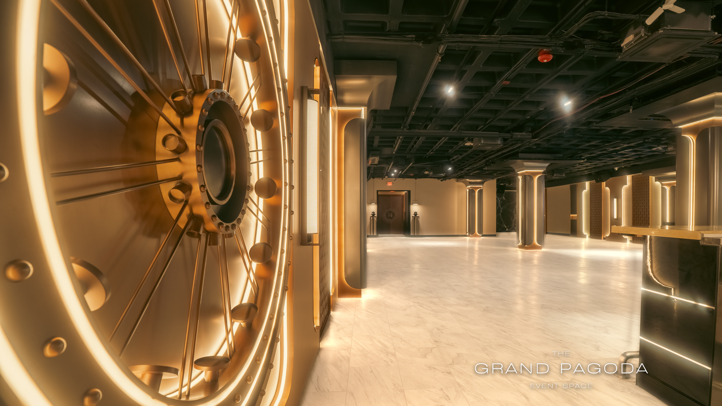 Modern event space with illuminated decor and a large decorative grid on the left wall, featuring warm lighting and marble flooring.
