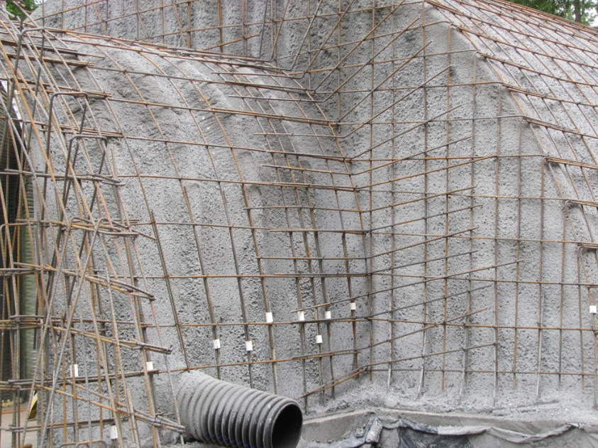 Construction site with concrete wall and steel rebar framework for reinforcement.