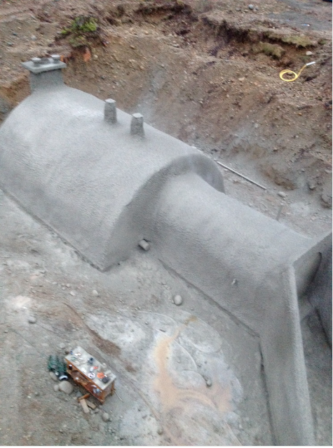 Concrete sewer or drainage pipe under construction in a trench.