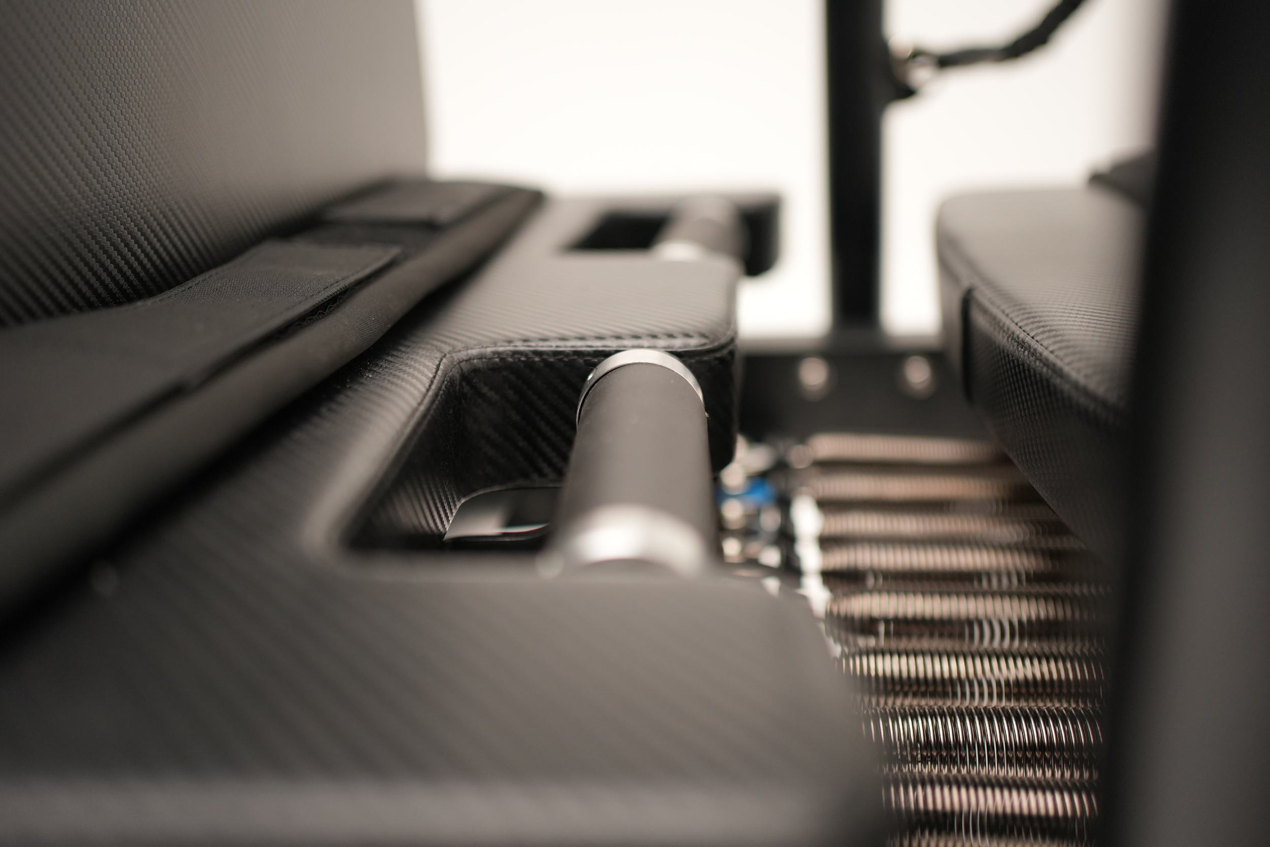 Close-up of carbon fiber interior details of a SculptFormer Reformer, including seats and a metal bar.
