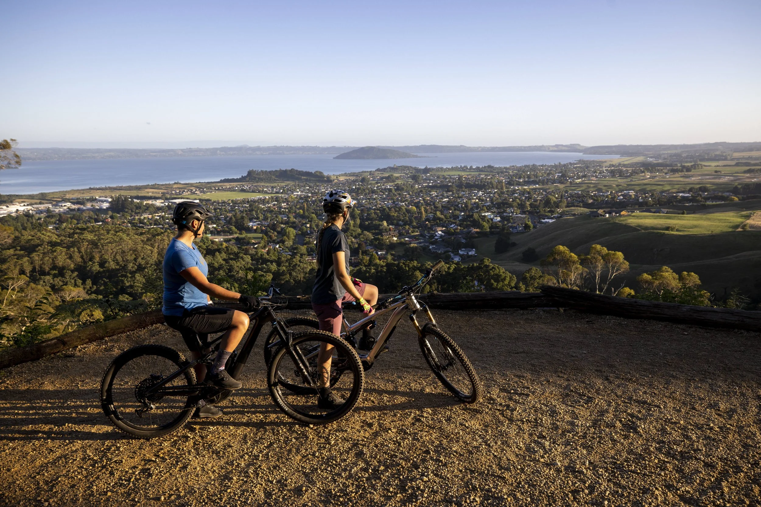 Two people over looking Rotorua from the Whakarewarea forest loop