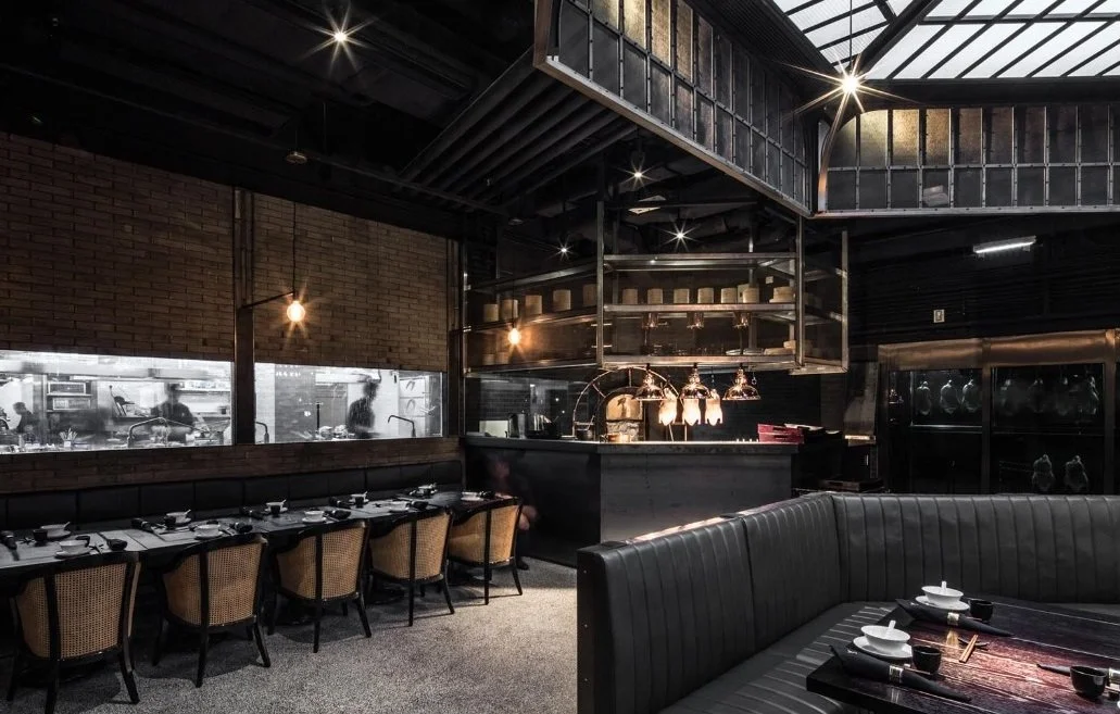 Mott 32, an award-winning Chinese Restaurant, interior dining area for viewing kitchen by Wang Fang Construction, featuring mix of modern and rustic decor, in Hong Kong Central.