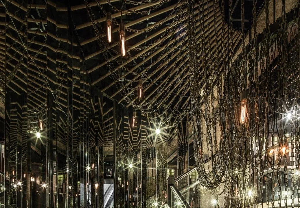 Mott 32, an award-winning Chinese Restaurant, interior dining area by Wang Fang Construction, showing chains and lighting hanging from the ceiling, creating a romantic ambience, in Hong Kong Central