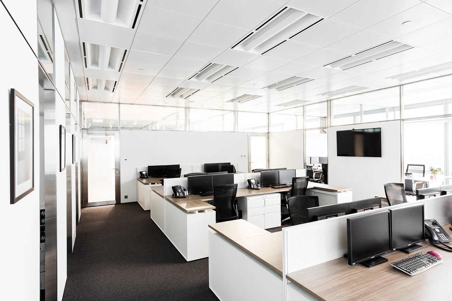 BBO office by Wan Fang Construction showing modern workspace with wooden desk, black mesh chairs, large windows and a minimalist, clean atmosphere in Hong Kong Central.