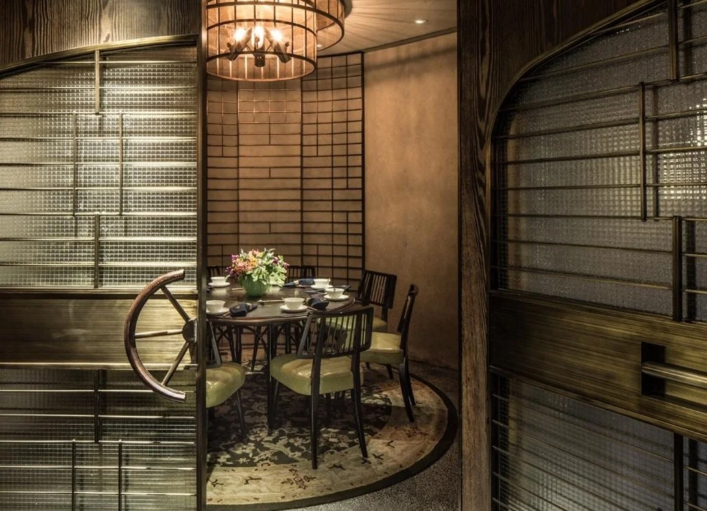 Mott 32, an award-winning Chinese Restaurant, private dining area by Wang Fang Construction, featuring a dark round table set for dining, and a mix of modern and rustic decor, in Hong Kong Central.
