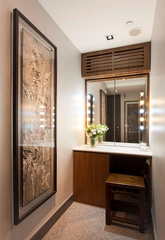 Bio Beauty Spa, a beauty boutique in Central Hong Kong by Wang Fang Construction, features a modern, minimalist interior. A central vanity with a wooden base, white countertop, and a large, lit mirror is the focal point. A slatted wooden cabinet hang