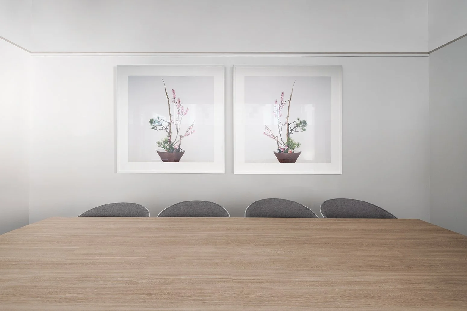 Panthevm Partners office by Wan Fang Construction showing conference room with a wooden table, grey chairs, framed artwork for a bright, collaborative workspace in Hong Kong, Central.