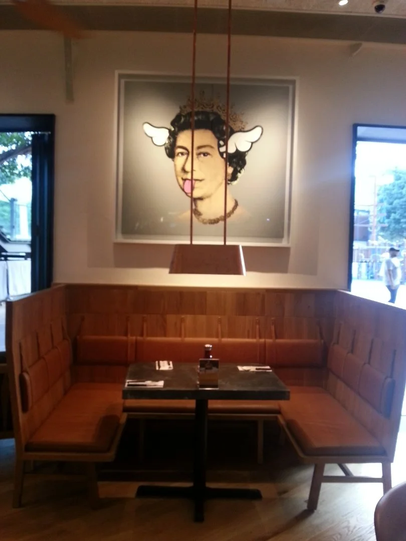 Beef & Liberty, a gourmet burger restaurant in Stanley Hong Kong by Wang Fang Construction, features a modern interior. The space has an exposed ceiling with recessed lighting and fans over polished hardwood floors. Long communal tables with leather 