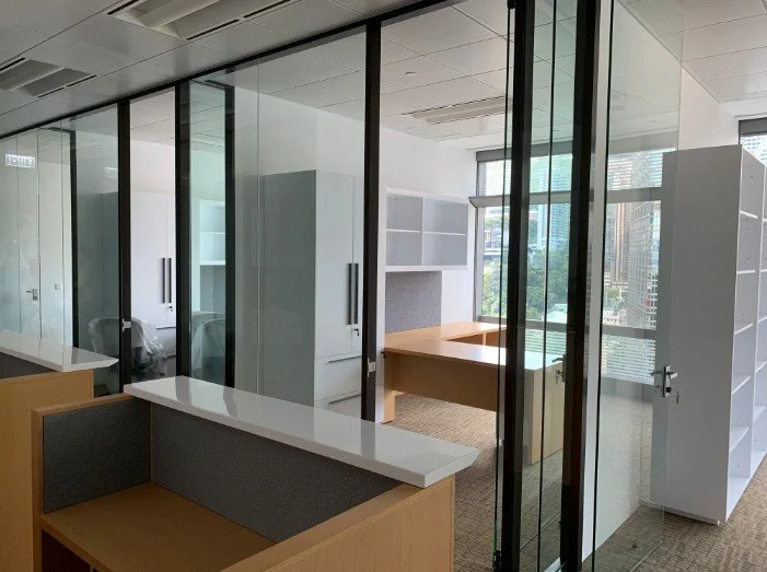 Debevoise & Pimpton office by Wan Fang Construction showing a modern workspace with glass walls, wooden desks, and abundant natural light in Hong Kong Central.