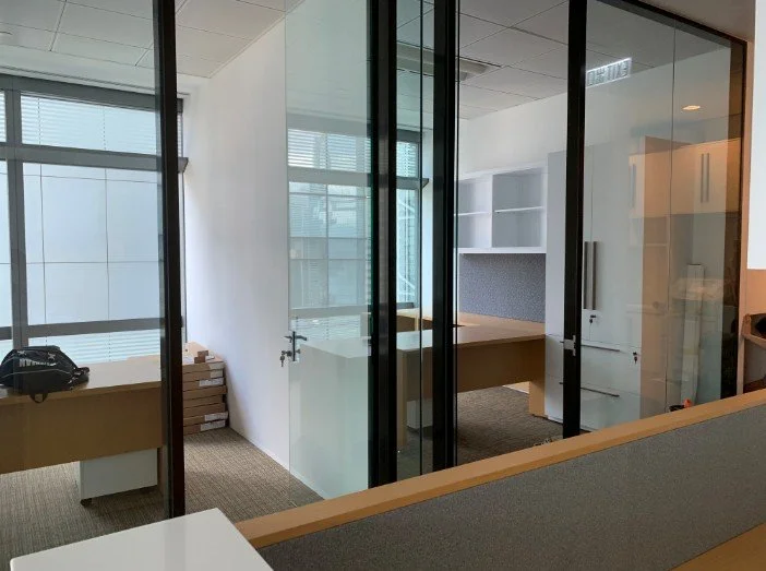 Debevoise & Pimpton office by Wan Fang Construction showing a modern workspace with glass walls, wooden desks, and abundant natural light in Hong Kong Central.