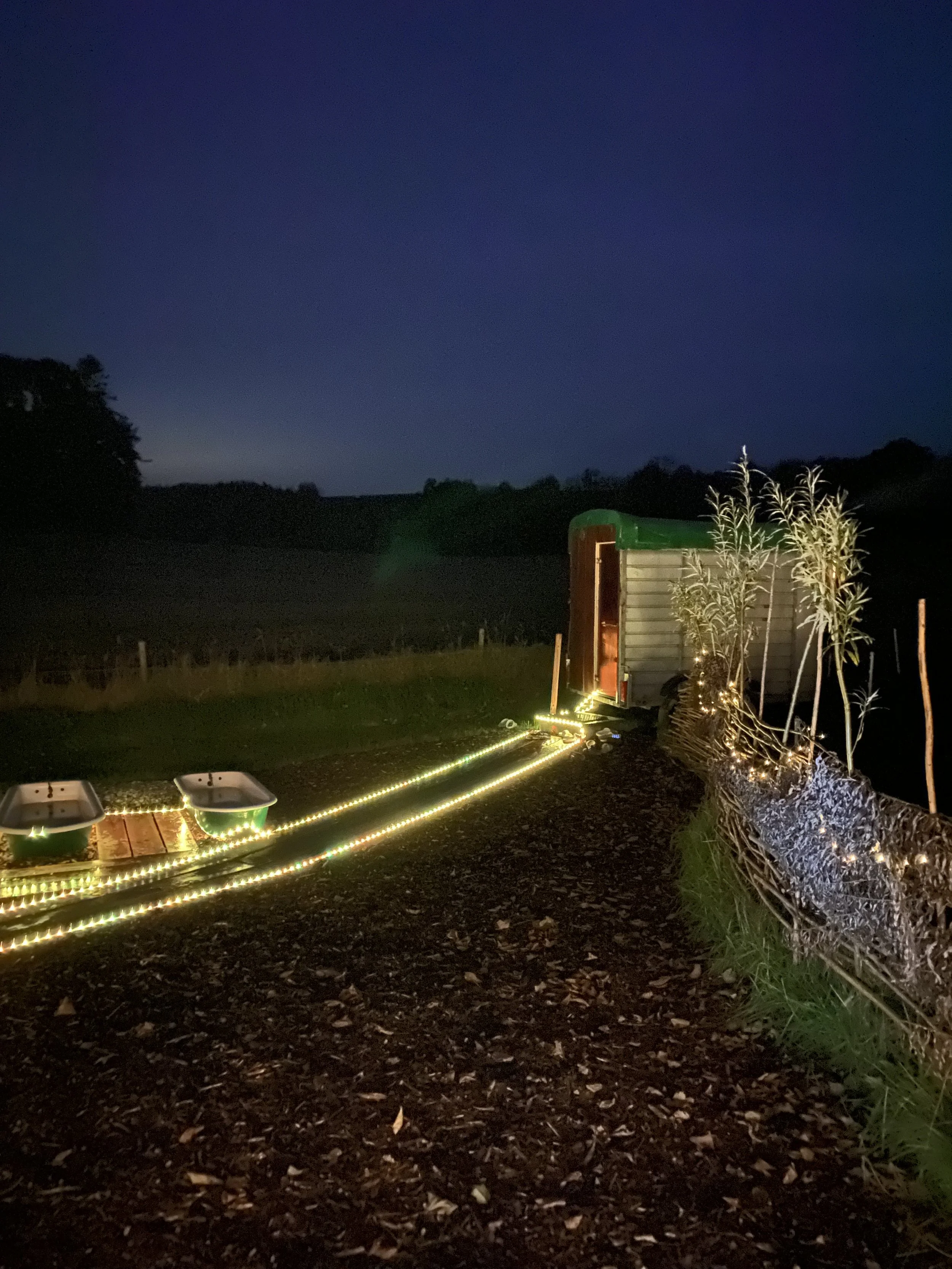Nighttime outdoor scene showing a rustic outdoor Sauna and natural water plunge pools at Hot rocks sauna Grangecon