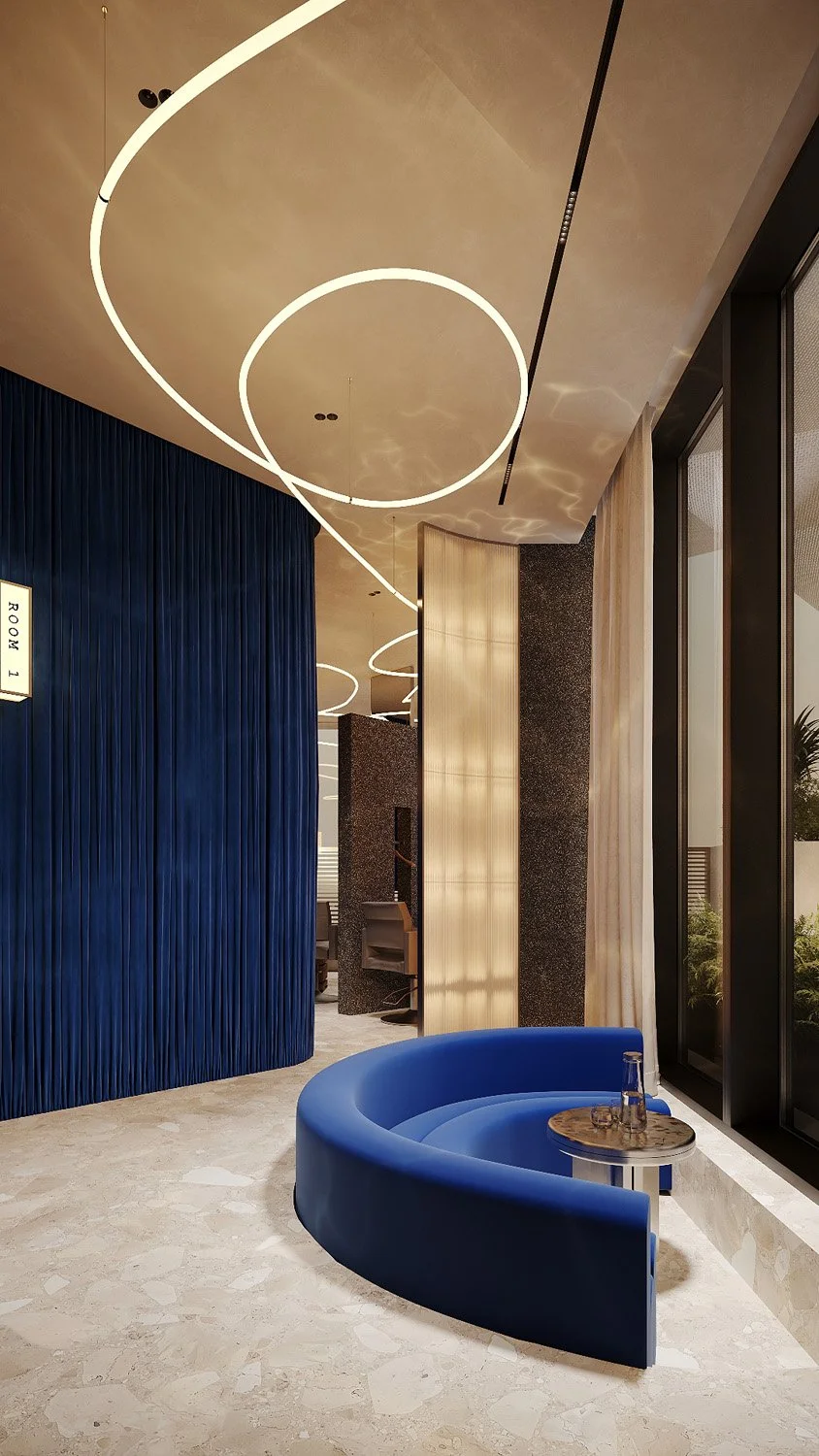 Sunken lounge at FŌM Hygge Spa, City Walk Dubai, by Limestone, with a curved electric blue velvet sofa, pleated velvet walls and sculptural linear lighting