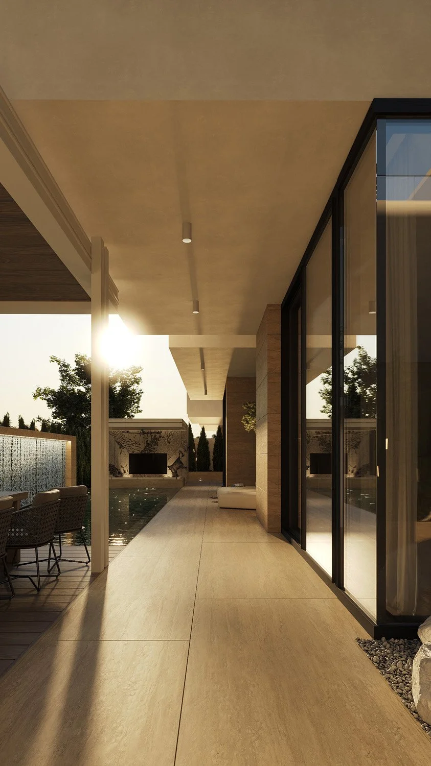 Poolside walkway in a Dubai Hills villa landscape, with travertine paving, a cascading water feature wall, and Sukabumi green tile pool, designed by Limestone