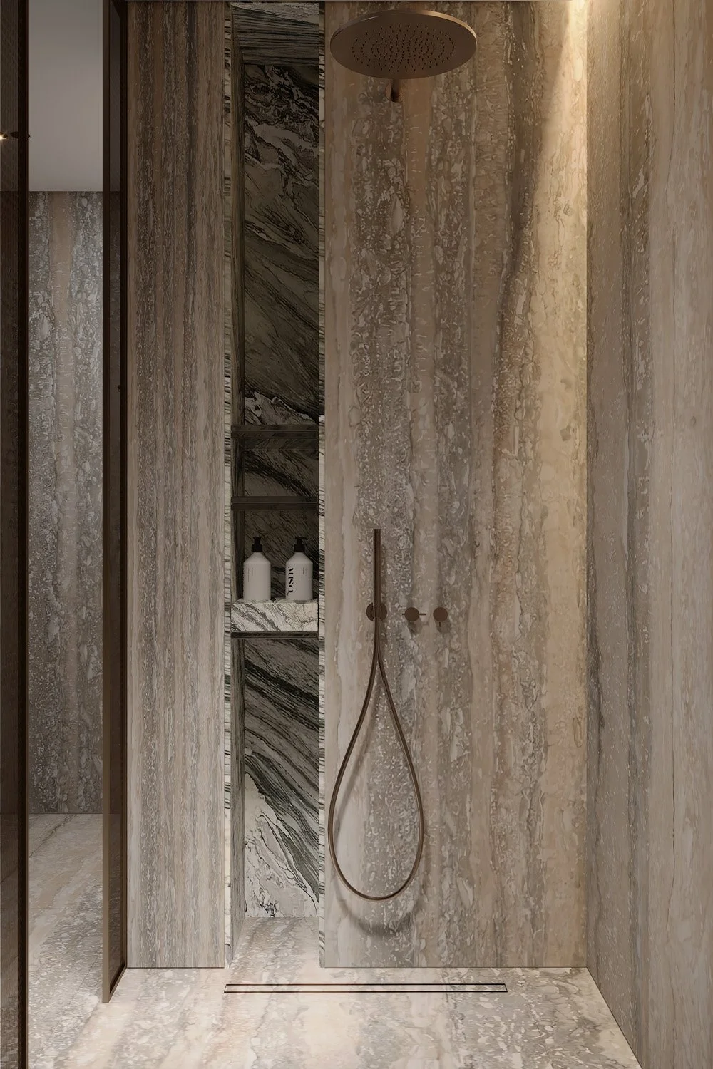 Walk-in shower detail in Villa Viola, Dubai Hills, with travertine wall cladding, a recessed dark marble niche, and bronze rainfall shower fixtures by Limestone