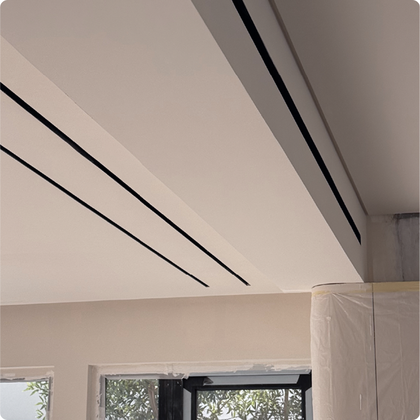 Ceiling with built-in air vents and a window showing trees outside.