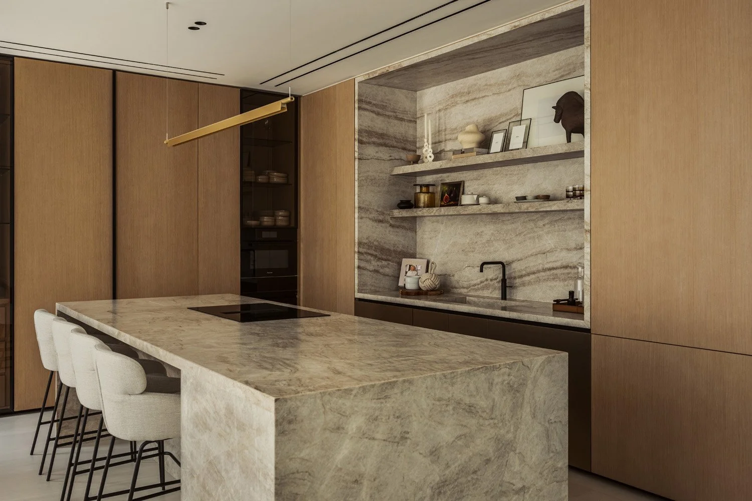 Taj Mahal quartzite kitchen island with cream bar stools, a quartzite-framed sink alcove and floor-to-ceiling oak joinery in Villa Ambra, Dubai.