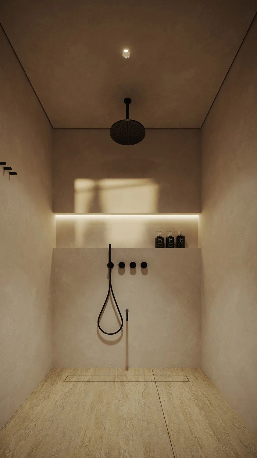 Outdoor shower in the self-contained washroom block of a Dubai Hills villa landscape, with plastered walls, travertine flooring, and matte black fixtures, designed by Limestone