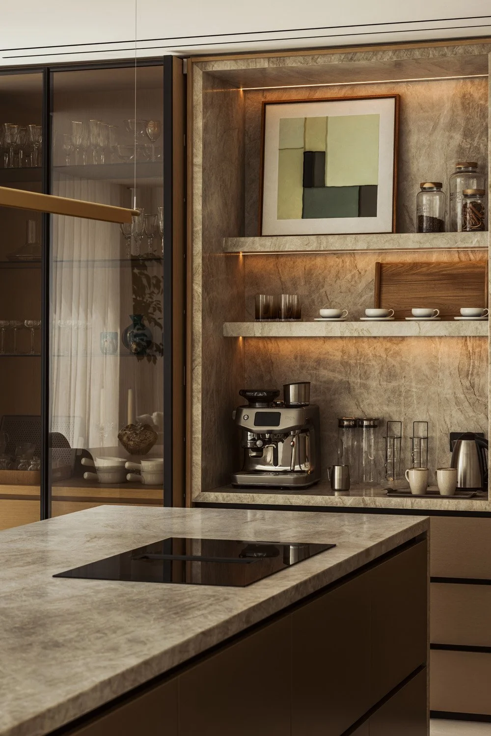 Concealed coffee station in the Villa Ambra kitchen, lined in leather-finish Taj Mahal quartzite with warm integrated shelf lighting, beside the quartzite island.